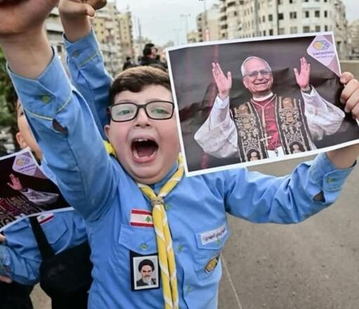 
Era il 30 novembre 2025. Casacca azzurra degli Scout al-Mahdi, stringeva in alto il ritratto del Papa con tutta la forza che aveva in corpo. Un ragazzino sciita di Beirut che urlava di felicità per un papa cristiano. 
8 aprile 2026 - primo giorno del cessate il fuoco tra Iran e Stati Uniti, mentre le famiglie iniziavano a prepararsi a tornare a casa - Israele ha scatenato uno dei suoi massacri più brutali: cento bombardamenti in dieci minuti su Beirut, sul sud del Libano e sulla valle della Bekaa. Quartieri residenziali rasi al suolo. Più di trecento morti in dieci minuti. Anche la casa di Jawad. Per tre giorni i soccorritori hanno cercato lui e suo padre Alì tra le macerie. L'11 aprile li hanno trovati.
Ma oggi, per chi guarda quella foto di novembre e poi pensa all'11 aprile, significa semplicemente questo: il bambino che impazzì di gioia è morto sotto le bombe. 